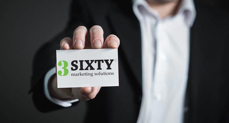 marketing agency person holding a 3SIXTY Marketing Solutions business card